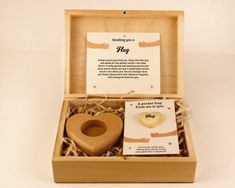 a wooden heart shaped object in a box with a note attached to the inside of it