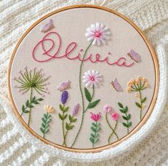 embroidered flowers and butterflies on a white background with the word delta written in pink embroidery