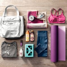 the contents of a gym bag laid out on top of a wooden floor next to yoga mats