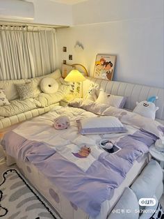 a large bed sitting in the middle of a living room next to a white couch