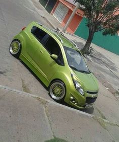 a small green car parked on the street