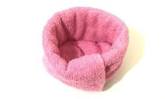 a pink dog bed is shown against a white background with the top part of it's head sticking out