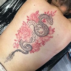 a woman with a snake and flowers tattoo on her back