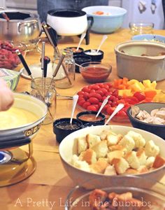 a wooden table topped with lots of different types of food and bowls filled with vegetables