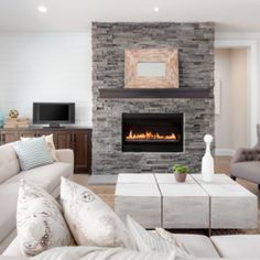 a living room filled with furniture and a fire place in the middle of the room