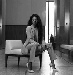 a black and white photo of a woman sitting on a chair