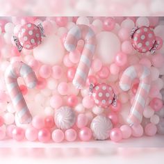 pink and white balloons are arranged on the wall