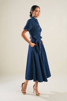 A textured denim midi dress featuring shirt collar, button down, short sleeve, self sash, side pockets and full skirt Details: Self : 100% Cotton Size & Fit - Model is 5`8" And Wearing Size Small- Measurements Taken From Size Small- Approx. Length: 49" Denim Blue Short Sleeve Dresses With Pockets, Chic Belted Button-up Denim Dress, Denim Blue Dress With Button Closure For Work, Denim Midi Dress With Pockets And Short Sleeves, Spring Short Sleeve Belted Denim Dress, Indigo Denim Short Sleeve Dress With Pockets, Medium Wash Denim Midi Dress With Short Sleeves, Denim Blue Short Sleeve Cotton Midi Dress, Denim Blue Cotton Midi Dress Short Sleeve