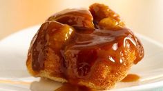 a donut covered in caramel sauce on a white plate