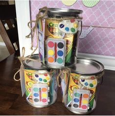 four tins with different colored paint on them