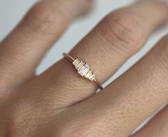 a woman's gold ring with three baguettes on the middle and sides