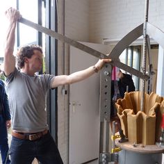 a man holding up a giant pair of scissors