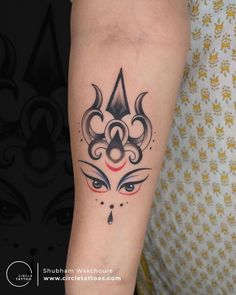 a woman's arm with a tattoo on it and an evil face in the center