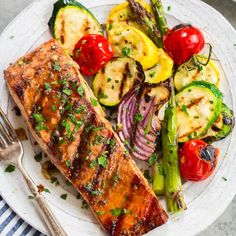 a white plate topped with grilled salmon and vegetables