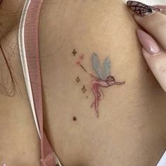 a small tattoo on the back of a woman's stomach, with a pink ribbon around her neck