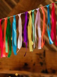 multicolored streamers hanging from the ceiling in a barn with other items on it