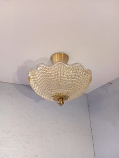 a ceiling light that is hanging from the ceiling in a room with white walls and flooring