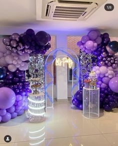 an entrance decorated with purple and silver balloons