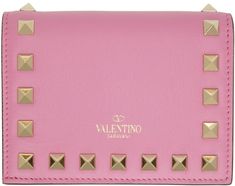 Grained leather wallet in pink. Burnished edges in black and signature pyramid studs throughout. Logo stamp in gold-tone at back face. Foldover flap with press-stud fastening. Patch pocket, zippered coin compartment, note slot, five card slots, and logo stamp at interior. Gold-tone hardware. Approx. 4.5 length x 3.25 height x 1 width. Supplier color: Dawn pink Pink Photo, Compact Wallet, Reversible Belt, Logo Stamp, Press Studs, Pyramid, Valentino Garavani, Patch Pocket, Leather Wallet