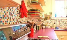 a stove top oven sitting inside of a kitchen next to a counter topped with pots and pans