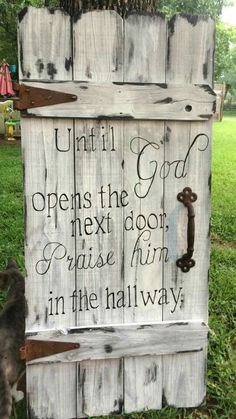 a wooden sign that reads until god opens the next door praise him in the hallway