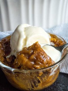 a glass bowl filled with dessert and ice cream on top of a black countertop