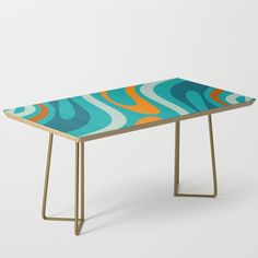 a table with an abstract design on the top and gold legs, against a white background