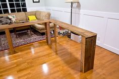 a living room with hard wood floors and a wooden table in front of the couch