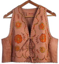 an orange and pink vest hanging on a wooden hanger