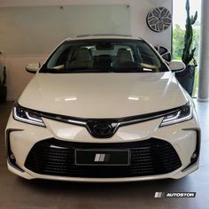 a white car is parked in a showroom