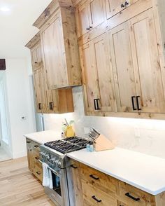 a kitchen with wooden cabinets and white counter tops, along with a stove top oven