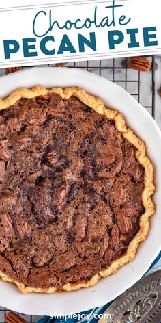 a chocolate pecan pie sitting on top of a white plate next to a sign