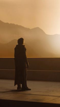 a person standing on top of a roof next to mountains