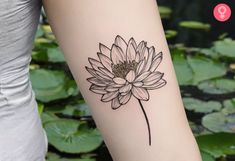 a woman's arm with a flower tattoo on it