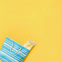 a blue and white striped bag sitting on top of a yellow table