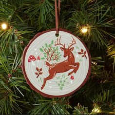 an ornament hanging from a christmas tree decorated with red and white deers