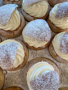 several pastries with white frosting and powdered sugar on top