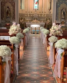 the aisle is decorated with flowers and ribbons