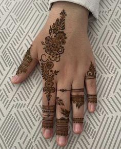 a woman's hand with henna tattoos on it