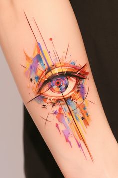 an eye tattoo on the arm with colorful paint splatters and lines around it