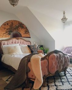 a bedroom with a pink bed, chandelier and rugs on the floor