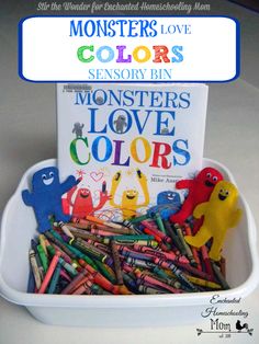 a white container filled with lots of colorful crayons next to a sign that says monsters love colors