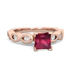 a rose gold ring with a red stone and two white diamonds