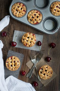 cherry pies in muffin tins with cherries on the side and forks