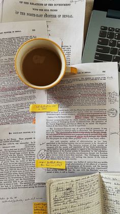 a cup of coffee sitting on top of an open book