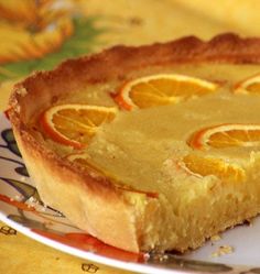 a close up of a slice of pie on a plate with oranges in the background