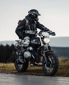 a man riding on the back of a motorcycle down a road