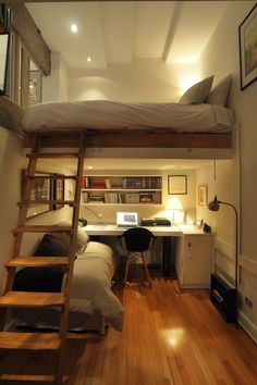 there is a loft bed with a desk and ladder to the top level above it