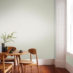 a table and chairs in a room with white walls