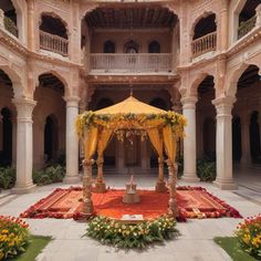 an elaborately decorated courtyard with yellow drapes and flowers